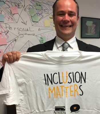 Jack proudly holds up a tshirt that says Inclusion Matter