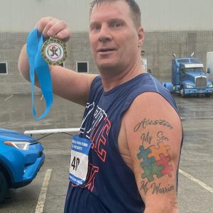 Successfully Determined Runner holds his medal after crossing the finish line