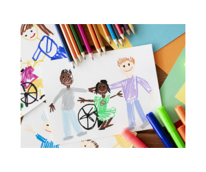 photo of a drawing of two children standing alongside a third child in a wheelchair. It's a child's sketch and it's lying on a table surrounded by colored pencils and markers.
