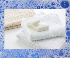 Background soapy bubbles with towels and soap in foreground
