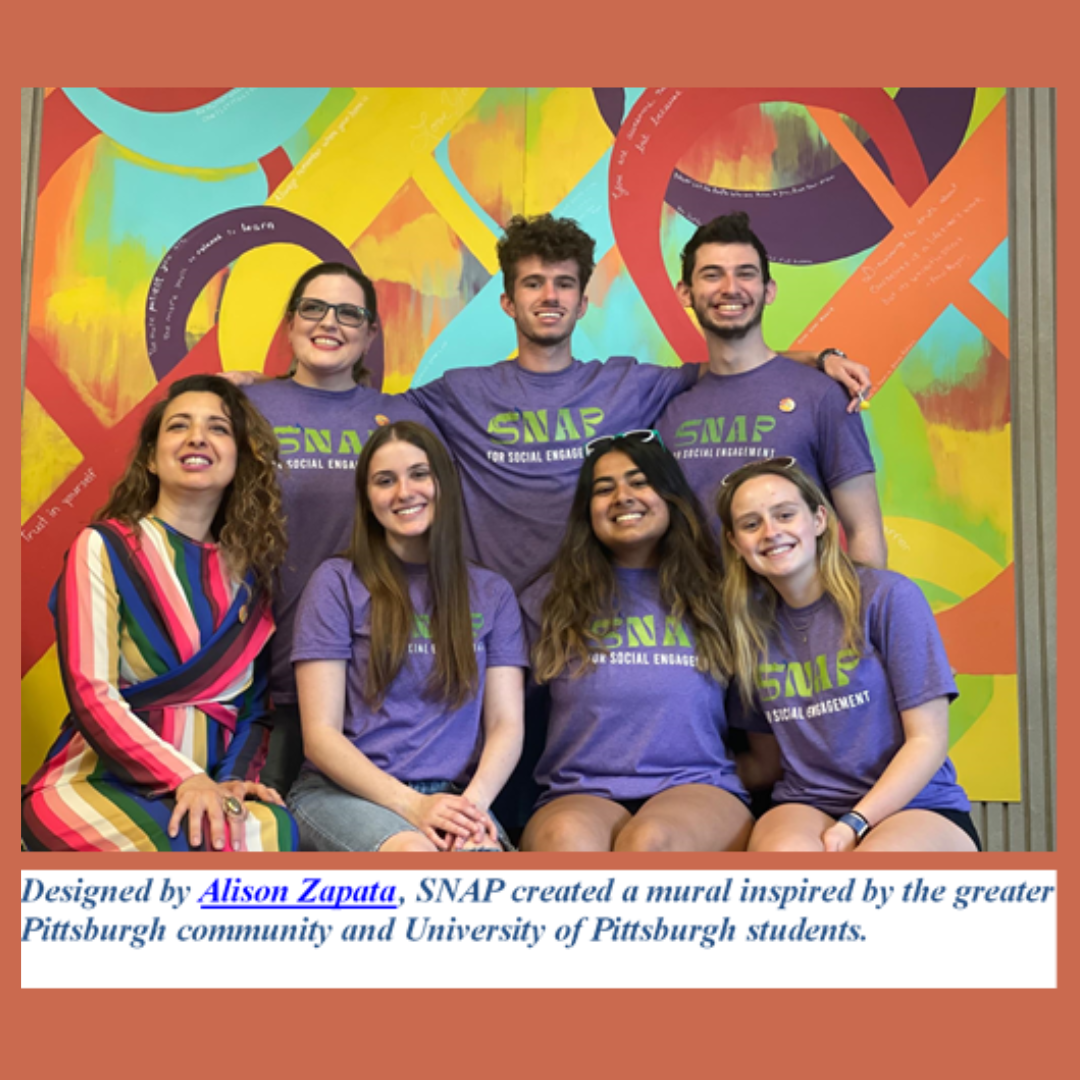 SNAP members sitting in front of a colorful mural